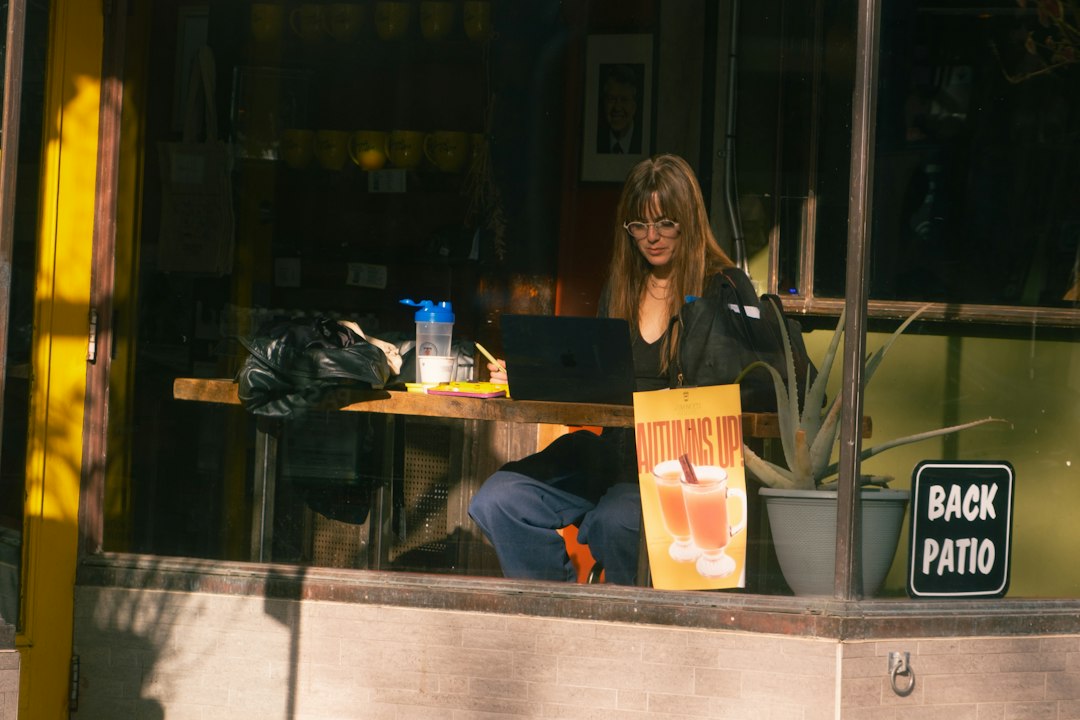 Woman working on laptop at outdoor cafe table